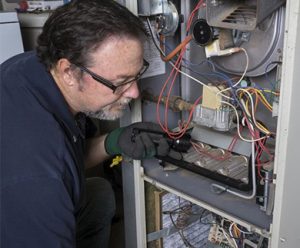 A professional doing an HVAC repair in Waukesha, WI